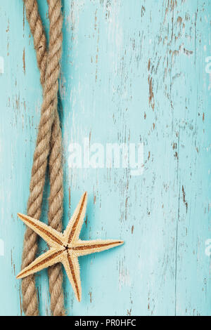 Rope and starfish on the background of an old wooden board with copy space Stock Photo