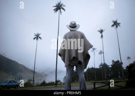 Colombian man from behind wearing a traditional ruana with panama hat