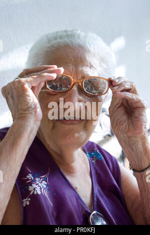 Close up portrait of an old lady adjusting her glasses in Bayamo Cuba Northern Caribbean America Stock Photo