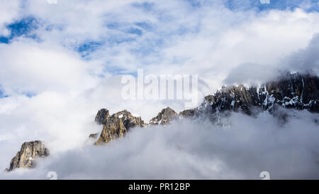 Jagged peaks from Biarchedi group of mountains appear behind clouds, Baltoro Galcier, Karakoram, Pakistan Stock Photo