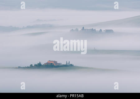 Early morning mist lingering among the villas and farmhouses within the Val d'Orcia, UNESCO World Heritage Site, Tuscany, Italy, Europe Stock Photo
