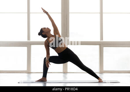 Young sporty attractive woman practicing yoga, doing Reverse War Stock Photo