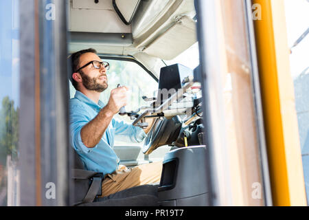 school bus driver losing door with lever and looking at rear mirror Stock Photo