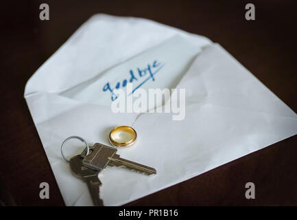On the table, she or he, left the keys, the wedding ring and a envelope with this word: Goodbye Stock Photo