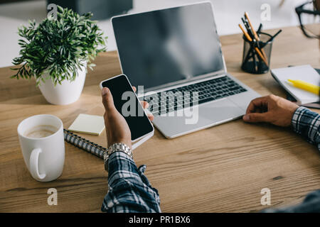 cropped shot of seo professional using laptop and smartphone at workplace Stock Photo