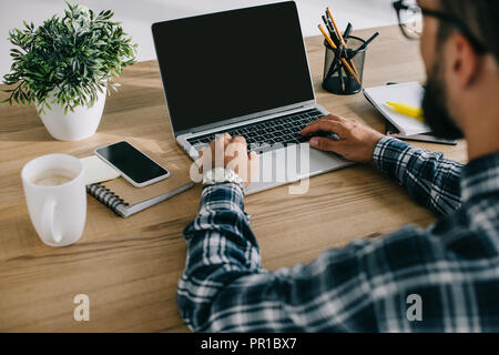 cropped shot of man in plaid shirt using laptop with blank screen Stock Photo