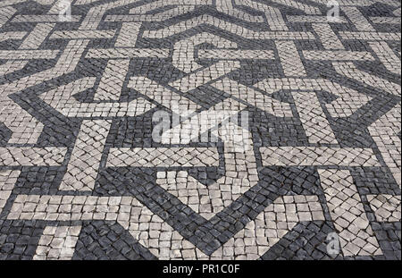 Typical Portuguese black and white stone mosaic calcada pavement - found throughout Portugal - Lisbon, Cascais, Guimaraes. Also in found in Brazil. Stock Photo