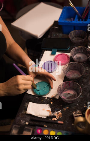 Woman mixing paint with brush Stock Photo