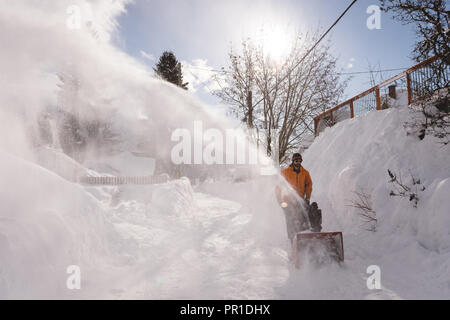 Man using snow blower machine in snowy region Stock Photo