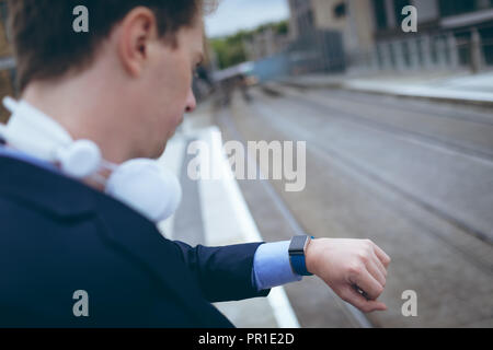Businessman checking time in his smartwatch Stock Photo