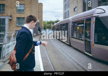 Businessman checking time in his smartwatch Stock Photo