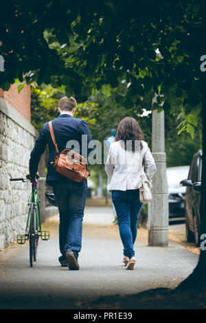 Business colleagues walking on sidewalk in city Stock Photo