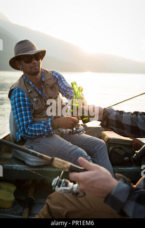 Two fishermen having beer while fishing in the river Stock Photo