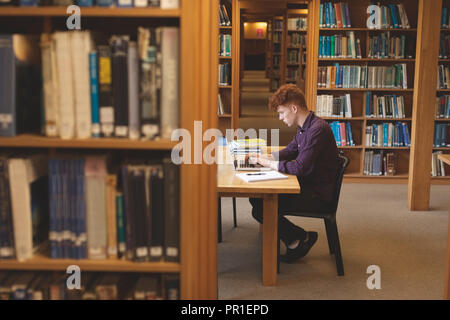 College student using laptop in library Stock Photo
