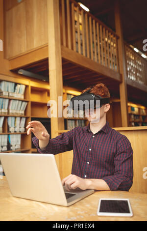 College student using laptop and virtual reality headset Stock Photo