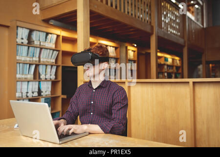 College student using laptop and virtual reality headset Stock Photo