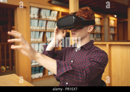 College student using virtual reality headset in library Stock Photo