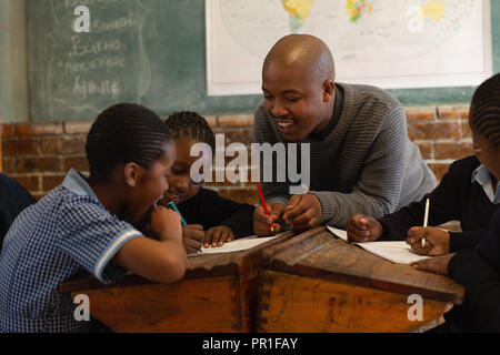Male teacher teaching students in the classroom Stock Photo