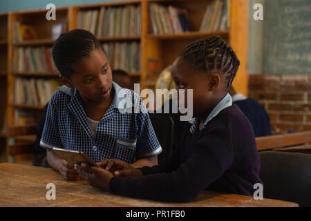 Schoolkids using digital tablet in classroom Stock Photo