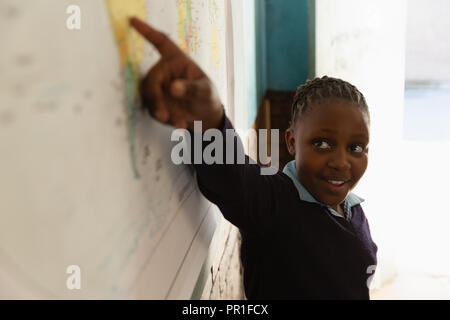 Schoolgirl explaining about world map in classroom Stock Photo