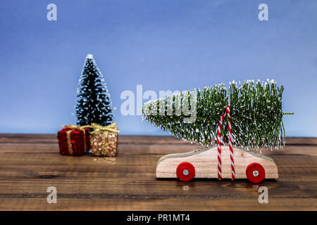 Wooden car with christmas tree and gift boxes on table top Stock Photo