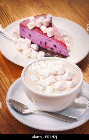 Cup of fresh hot chocolate drink with delicious  piece of blueberry cake on the wooden table Stock Photo