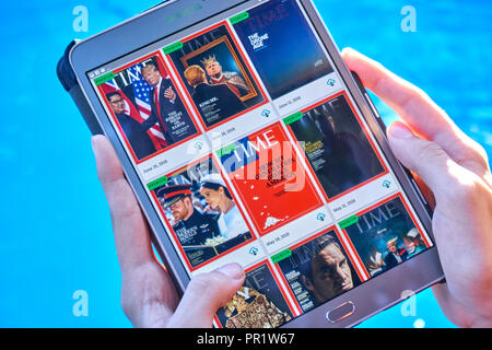 MONTREAL, CANADA - SEPTEMBER 8, 2018: Time magazines on a Samsung Galaxy tablet in hands. Stock Photo