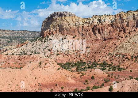 Colorful valley, cliffs, and mesa under a bright blue sky with puffy white clouds near Abiquiu, New Mexico in the American Southwest Stock Photo
