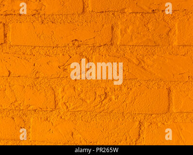 Modern vibrant orange stone brick wall with big bricks close up background pattern Stock Photo