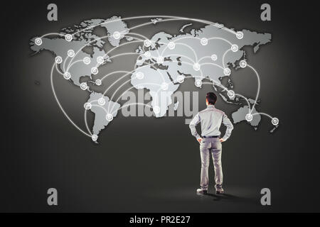 business man standing in front of world map background Stock Photo
