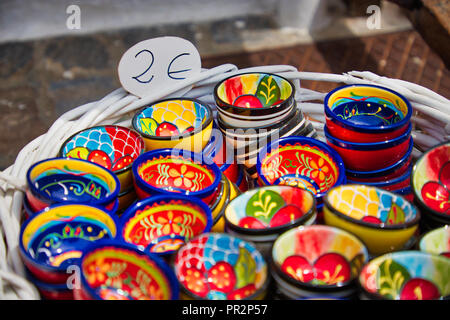 Closeup of a basket of colorful souvenir bowls for sale for 2 Euros at a market in Sagunto, Spain Stock Photo