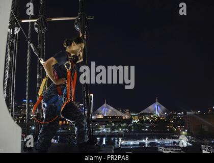 (JULY 23, 2017) Gunner's Mate 2nd Class Erin Bullock, assigned to USS Constitution, stands on the fighting top of Old Ironsides after climbing the rigging  during the undocking of the ship. Over the past 26 months, Constitution has undergone an extensive restoration that will help to preserve America’s ship of state for many decades to come. Stock Photo