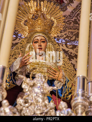 Closeup of an ornate Catholic statue of a crying Mary with gold and silver Stock Photo