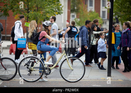 Manchester Oxford Road cycle lane, lady cyclist waiting at red light