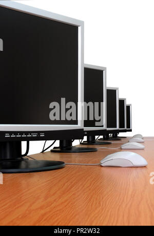 Row of computer monitors in classroom. White background, isolated. Stock Photo