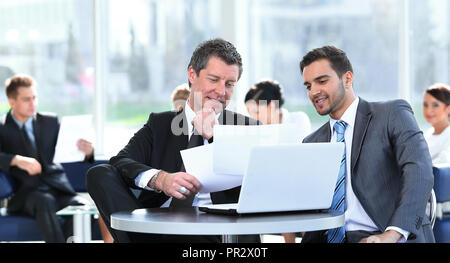 business partners discussing a new project, sitting in the lobby of the office. Stock Photo