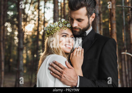 beautiful wedding couple hugging in forest Stock Photo
