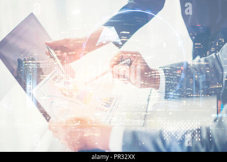 Double Exposure, Image of two young businessmen using touchpad at meeting Stock Photo