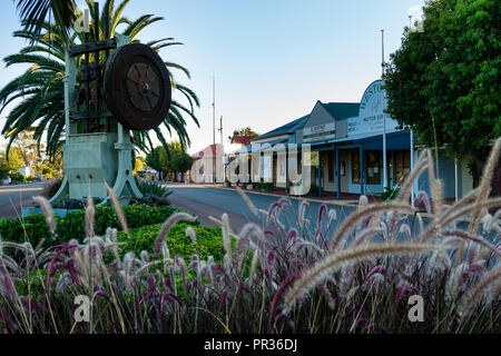 Old gold battery celebrating mining past in main street with historical shop facades in the background, Westonia Western Australia Stock Photo