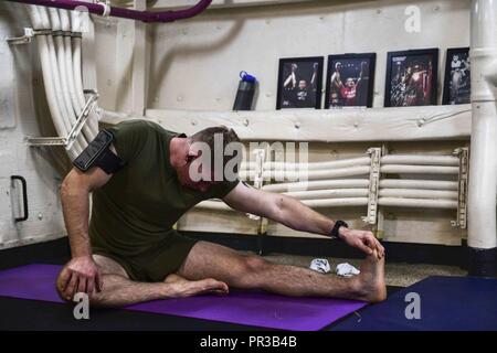 INDIAN OCEAN (Dec. 26, 2017) Marine Capt. Frank Halstead stretches out before conducting his workout aboard the amphibious transport dock ship USS San Diego (LPD 22). San Diego, part of the America Amphibious Ready Group, with embarked 15th MEU, is operating in the Indo-Asia Pacific region to strengthen partnerships and serve as a ready-response force for any type of contingency. Stock Photo