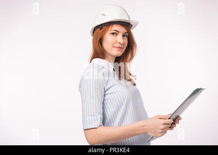 Architect, worker and realtor concept - woman builder or engineer in helmet with documents on white background with copy space. Stock Photo