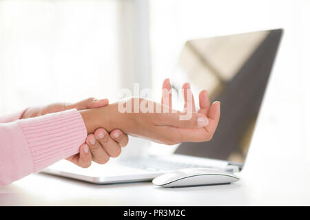 Closeup woman holding her wrist pain from using computer. Office syndrome hand pain by occupational disease. Stock Photo