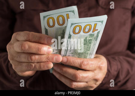 Cash bills from USA currency. Dollars. Front view of old woman's hand handling bills. Stock Photo