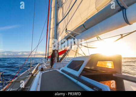 Sailing on sailboat yacht with beautiful sunset light clear blue sky and flat sea in drake passage, summer cruising, closeup of boat deck Stock Photo