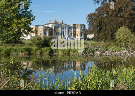 Waverley Abbey House, a charming Grade II listed Georgian mansion, reflected in the lake, among mature trees in autumn, Surrey, UK Stock Photo