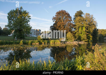 Waverley Abbey House, a charming Grade II listed Georgian mansion, reflected in the lake, among mature trees in autumn, Surrey, UK Stock Photo