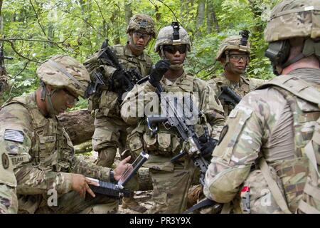 U.S. Army Soldiers assigned to the 65th Brigade Engineer Battalion (BEB), 2nd Brigade Combat Team, 25th Infantry Division discuss strategies using the Engineering Field Planning, Reconnaissance, Surveying, and Sketching Set to access critical data and find tactical information about the Muscatatuck River for a training exercise at Muscatatuck Urban Training Center, Ind., July 27, 2017. The 65th BEB, stationed out of Schofield Barracks, Hawaii, spent two weeks in southern Indiana for urban training operations. Stock Photo