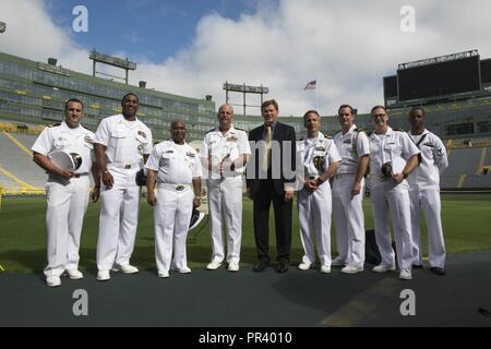 GREEN BAY, Wis. (July 28, 2017) – Rear Adm. Bruce L. Gillingham, Deputy Chief, Bureau of Medicine and Surgery, Readiness & Health, and Mark Murphy, president and chief executive officer for the Green bay Packers of the National Football League, join a group of Sailors for a photo on Lambeau Field, home of the Green Bay Packers football team, during Green Bay/Fox Cities Navy Week. Navy Week programs serve as the U.S. Navy's principal outreach effort into areas of the country that lack a significant Navy presence, helping Americans understand that their Navy is deployed around the world, around  Stock Photo