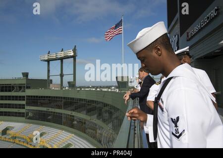 GREEN BAY, Wis. (July 28, 2017) – Boatswain’s Mate 3rd Class Jalen Walker, a native of Milwaukee, peers over the railing onto Lambeau Field, home of the Green Bay Packers football team, during Green Bay/Fox Cities Navy Week. Navy Week programs serve as the U.S. Navy's principal outreach effort into areas of the country that lack a significant Navy presence, helping Americans understand that their Navy is deployed around the world, around the clock, ready to defend America at all times. Stock Photo