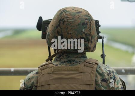 U.S. Marine Corps Capt. Jonathan E. Dewitt, a forward air controller with the 26th Marine Expeditionary Unit (MEU), sights in on a target during Tactical Air Control Party (TACP) training at Piney Island, N.C., July 25, 2017. Marines conducted TACP training to maintain proficiency in utilizing air power in preparation for an upcoming deployment at sea. Stock Photo